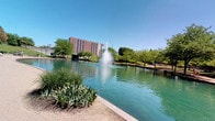 Situated at 434 Canal Court in Indianapolis, Indiana, this single-story space enjoys a prime position along the iconic Indianapolis Central Canal. The outdoor environment is a defining feature of this property, offering sweeping views of the tranquil canal waters, highlighted by a striking central fountain that serves as a visual focal point. The surrounding landscape is rich with mature trees and well-maintained green spaces, creating a serene, park-like atmosphere just steps from the front door. A beautifully laid brick paver walkway curves along the canal's edge, providing a welcoming and polished pedestrian experience. The backdrop of the Indianapolis skyline is visible on the horizon, blending urban energy with natural calm. The area benefits from abundant natural light, open skies, and the soothing sounds of flowing water. This location places residents or visitors within close proximity to the cultural and recreational amenities of downtown Indianapolis, while the canal-side setting offers a peaceful retreat from the bustle of city life. The combination of thoughtful landscaping, water features, and urban views makes this an exceptionally distinctive and memorable address.