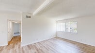 Located at 16900 Algonquin St in Huntington Beach, CA, this single-floor home offers four bedrooms and two bathrooms within a well-organized layout. The open living room flows seamlessly into the dining and kitchen area, featuring light wood-style flooring, textured ceilings with exposed beams, and large windows with vertical blinds that invite ample natural light. A ceiling fan adds comfort to the living space.

The galley-style kitchen is outfitted with white cabinetry, marble-patterned countertops, a stainless steel double sink, a gas range, and a built-in microwave — providing efficient use of space with clean, bright finishes.

The four bedrooms are thoughtfully distributed throughout the home. Several rooms feature light wood-style flooring, while others are finished with plush carpet. Ceiling fans are present in multiple bedrooms, and closets with bifold doors offer built-in storage. The primary bedroom is generously sized with a large window that fills the room with natural light.

Both bathrooms are finished in a clean, all-white palette with tub-shower combinations, chrome fixtures, and wood-style tile flooring. One bathroom features a high window above the tub for additional ventilation and light. Two hallways connect the rooms, contributing to the home's efficient and functional flow.