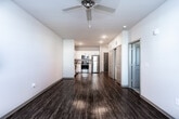 This single-floor residence in Douglasville, Georgia offers a thoughtfully designed open-concept layout that maximizes both functionality and comfort. Rich wood-style flooring flows throughout the main living areas, creating a warm and cohesive aesthetic.

The kitchen is a standout feature, equipped with a full suite of stainless steel appliances including a refrigerator, electric range, microwave, and dishwasher. Crisp white cabinetry extends to the ceiling for ample storage, complemented by granite-style countertops and a double-basin sink — delivering a clean, modern look.

The open living area is generously proportioned, bathed in natural light and fitted with recessed lighting overhead. A dedicated hallway leads to the bedroom spaces, which feature plush carpeting, ceiling fans, and window blinds for privacy and light control. The bedrooms offer comfortable proportions suited for a variety of furniture arrangements.

The bathroom is well-appointed with a vanity, full-size soaking tub, and a bright, functional layout. A spacious walk-in closet with built-in wire shelving provides excellent storage capacity. Additionally, an in-unit laundry closet adds everyday convenience. The space combines practical design with modern finishes throughout.