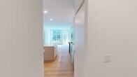 Located at 1529 N Fremont St in Chicago's Lincoln Park neighborhood, this modern 2-bedroom, 3-bathroom residence offers a thoughtfully designed single-level layout finished with light hardwood flooring throughout. The open-concept kitchen and living area anchors the space, featuring sleek flat-front cabinetry in a muted gray tone, white quartz countertops, stainless steel appliances, and a central island that provides additional prep and seating space. Large floor-to-ceiling windows in the living area flood the space with natural light and open to a private balcony with outdoor views. Each bedroom is well-proportioned, with the primary bedroom offering a closet and its own dedicated bathroom. The second bedroom also benefits from generous natural light and a wall-mounted mini-split HVAC unit. All three bathrooms are finished in a consistent modern aesthetic, highlighted by warm wood vanities, matte black fixtures, and distinctive green-and-white checkered tile surrounds in the shower and tub enclosures. Clean white walls and recessed lighting contribute to a bright, contemporary ambiance throughout. The overall design emphasizes minimalism and functionality, making efficient use of the available space.