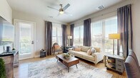 This well-appointed 2-bedroom, 2-bathroom residence in Rancho Cordova, California offers a thoughtfully designed single-level layout that balances comfort and functionality. The open-concept living area is bathed in natural light through large windows dressed with elegant floor-to-ceiling drapes, and features light hardwood-style flooring and a ceiling fan overhead. The living room flows seamlessly into the dining area, creating an inviting space for both relaxing and entertaining.

The kitchen is equipped with stainless steel appliances — including a side-by-side refrigerator with ice and water dispenser, range, and built-in microwave — complemented by generous gray shaker cabinetry and clean white countertops. Recessed lighting and a U-shaped layout maximize both style and workspace efficiency.

The primary bedroom offers plush carpeting, a ceiling fan, and a large window with outdoor views, connected to a full en-suite bathroom featuring a soaking tub, dual-sink vanity, and wood-tone cabinetry. The second bedroom is equally well-sized with natural light and easy access to a second full bathroom with a stylish barn door detail. Additional highlights include multiple closets, a dedicated laundry area, and a private balcony accessible from the main living space.