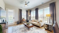 This well-appointed 2-bedroom, 2-bathroom residence in Rancho Cordova, California offers a thoughtfully designed single-level layout that balances comfort and functionality. The open-concept living area is bathed in natural light through large windows dressed with elegant floor-to-ceiling drapes, and features light hardwood-style flooring and a ceiling fan overhead. The living room flows seamlessly into the dining area, creating an inviting space for both relaxing and entertaining.

The kitchen is equipped with stainless steel appliances — including a side-by-side refrigerator with ice and water dispenser, range, and built-in microwave — complemented by generous gray shaker cabinetry and clean white countertops. Recessed lighting and a U-shaped layout maximize both style and workspace efficiency.

The primary bedroom offers plush carpeting, a ceiling fan, and a large window with outdoor views, connected to a full en-suite bathroom featuring a soaking tub, dual-sink vanity, and wood-tone cabinetry. The second bedroom is equally well-sized with natural light and easy access to a second full bathroom with a stylish barn door detail. Additional highlights include multiple closets, a dedicated laundry area, and a private balcony accessible from the main living space.