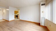 Located at 3812 Bates St in Pittsburgh's 15213 zip code, this two-bedroom, two-bathroom residence offers a practical and well-organized single-floor layout. The living room is the heart of the home, featuring light wood laminate flooring, neutral white walls, warm wood baseboards, and a large window fitted with vertical blinds that allow generous natural light to fill the space. An open sightline connects the living area to the galley-style kitchen, which is outfitted with warm honey-toned wood cabinetry, white countertops, tile flooring, a stainless steel refrigerator, a stainless range, and a dishwasher — providing ample storage and functionality. Both bedrooms continue the light wood flooring theme and feature windows that bring in natural light, with the primary bedroom offering a comfortable and spacious feel. Four closets throughout the unit provide substantial storage. The two bathrooms are finished with white tile surrounds, soaking tubs with shower fixtures, and wood-accented vanities. The entrance provides a welcoming transition into the home. Overall, the unit presents a clean, neutral palette with consistent finishes throughout, making it a functional and comfortable residence.