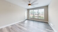 Located at 4805 W Genesee St in Syracuse, NY, this well-appointed 2-bedroom, 1-bathroom unit offers a thoughtfully designed single-floor layout with modern finishes throughout. Light gray hardwood-style flooring flows seamlessly across all living areas, complemented by neutral warm-toned walls and crisp white trim, creating a clean and contemporary aesthetic.

The open-concept kitchen is a standout feature, showcasing rich dark espresso cabinetry, stone countertops with natural veining, a herringbone tile backsplash, and a full suite of stainless steel appliances including a refrigerator, range, microwave, and dishwasher. A kitchen island with matching stone countertop provides additional prep and seating space, while recessed lighting illuminates the area.

The living room benefits from large windows that invite abundant natural light and outdoor views, enhanced by a ceiling fan overhead. The spacious primary bedroom offers generous proportions, while the second bedroom features a large window with a pleasant outdoor view and access to a dedicated closet.

The bathroom is elegantly finished with a double-sink vanity topped with marble-style stone countertops, rich dark wood cabinetry, modern light fixtures, and a glass-enclosed shower. A dedicated laundry room houses a full-size washer and dryer alongside additional counter space, completing this well-equipped home.