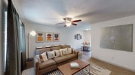 This 2-bedroom, 2-bathroom home in Baton Rouge, Louisiana presents a practical and well-organized single-floor layout. The open living area features a textured ceiling with a ceiling fan, neutral walls, and wood-look flooring that extends into the adjacent dining space. The dining area is highlighted by a sliding glass door dressed with vertical blinds, allowing natural light to filter in and offering a view of the surrounding greenery outside.

The kitchen is outfitted with rich, warm-toned cabinetry, granite-style countertops, and a full suite of stainless steel appliances, including a refrigerator, electric range with over-the-range microwave, and dishwasher. Ample upper and lower cabinet storage adds to the kitchen's functionality.

Both bedrooms are carpeted and include ceiling fans, natural light from windows with blinds and curtain panels, and dedicated closet space. One bedroom features a walk-in closet with built-in shelving, providing generous storage. Each room offers a cozy, well-lit retreat.

The bathrooms are finished with wood-look flooring, rich cabinetry with granite-style countertops, and tub-shower combinations. The overall design throughout the residence is clean and neutral, creating a versatile living environment suited to a variety of styles.