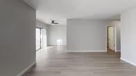 Located at 22416 Ocean Ave in Torrance, CA 90505, this thoughtfully updated single-floor residence offers a clean, modern aesthetic with quality finishes throughout. The open living and dining area features light hardwood flooring, soft neutral walls, and a ceiling fan, while sliding glass doors flood the space with natural light and provide access to an outdoor area. The kitchen is outfitted with white shaker-style cabinetry, stone countertops, a deep stainless steel undermount sink with a pull-down faucet, and a stainless steel dishwasher — all set against light hardwood floors that continue the home's cohesive design. The bedrooms are carpeted for comfort, with neutral tones and natural light from windows fitted with blinds. The larger bedroom includes mirrored sliding closet doors that add depth and storage. The bathroom is finished to a high standard, featuring a wide stone-topped vanity with an undermount sink, a large wall mirror, recessed lighting, light hardwood flooring, and a tiled walk-in shower. Every detail of this residence reflects a commitment to clean, functional design, making it a well-appointed home in a desirable Torrance location.