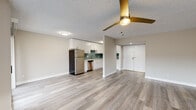 This single-floor residence offers a thoughtfully updated interior with a cohesive, modern design. The open-concept living and dining area is anchored by light-toned luxury vinyl plank flooring and a stylish gold ceiling fan, creating a bright and welcoming atmosphere. A fireplace with a classic surround adds character to the living space, which also benefits from a large window that invites natural light.

The kitchen is a standout feature, showcasing white shaker-style cabinetry, light quartz countertops, and a teal subway tile backsplash that adds a pop of color. A full suite of stainless steel appliances — including a refrigerator, range, microwave, and dishwasher — completes the functional and attractive cooking space.

The bedrooms are finished with soft wall-to-wall carpeting and neutral walls, providing a comfortable and quiet retreat. Each room is well-proportioned, with windows offering outdoor views. The bathroom is finished with clean white subway tile surrounding a full soaking tub and shower, fitted with chrome fixtures for a crisp, polished look.

Throughout the space, textured ceilings, white trim, and a neutral color palette tie the rooms together, delivering a clean and move-in-ready environment suitable for everyday living.