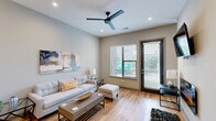 Located at 1818 Park Ave in Dallas, TX, this well-appointed one-bedroom, one-bathroom residence offers a thoughtfully designed open-concept floor plan that maximizes every square foot. Light hardwood flooring flows seamlessly throughout the living spaces, complementing the clean, contemporary aesthetic.

The combined living, dining, and kitchen area forms the heart of the home. The living room features a modern ceiling fan, recessed lighting, and a glazed door alongside large windows that invite natural light and provide outdoor views. The kitchen is a standout, outfitted with sleek grey flat-front cabinetry, a tile backsplash, full stainless steel appliances including a French door refrigerator and slide-in range, and a dark-topped center island with bar seating and stylish pendant lighting overhead.

The spacious primary bedroom offers a comfortable retreat, complete with a wall-mounted electric fireplace and ample natural light. Two closets provide generous storage. The bathroom is finished with striking marble-look tile flooring, large-format wall tile in the walk-in glass shower, and a clean floating vanity. Additional practicalities include a dedicated laundry area and a utility room. The unit delivers a polished, modern living experience in the heart of Dallas.