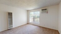 Located at 3545 Mather Field Rd in Rancho Cordova, CA, this one-bedroom, one-bathroom unit offers a practical and efficient single-floor layout. The living room is carpeted and bathed in natural light through a large sliding window fitted with vertical blinds, offering views of surrounding greenery. A wall-mounted heater provides in-unit climate control, complementing the wall-unit air conditioner found in the bedroom. The bedroom is a comfortable, well-proportioned space with plush carpeting, a large window with vertical blinds, and its own wall-mounted AC unit for independent temperature control. Two closets offer ample storage throughout the unit. The galley-style kitchen features warm wood cabinetry, light countertops, a stainless steel sink, and light wood-look vinyl flooring, with space for a range and dishwasher. A dedicated dining area adjoins the kitchen for convenient meal times. The bathroom is finished with light vinyl flooring, a wood-cabinet vanity topped with a speckled countertop and a large mirror, plus a full bathtub and shower. A hallway connects the main living areas, completing this well-organized and functional floor plan.