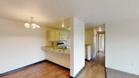 Located at 2301 North Wilbur Road in Spokane Valley, Washington, this single-floor unit offers a practical and well-organized layout designed for comfortable everyday living. The open-concept living and dining area features warm wood-style flooring that transitions seamlessly into the kitchen zone, while plush carpeting defines the living room space. A chandelier adds a welcoming accent above the dining area, and a sliding glass door fills the living room with natural light while providing access to a private balcony with outdoor views.

The kitchen is efficiently designed in a U-shaped configuration, featuring light-toned cabinetry, a double-basin sink, a full suite of white appliances including a refrigerator, electric range, built-in microwave, and dishwasher, as well as a peninsula breakfast bar ideal for casual dining.

The bedrooms are carpeted and well-lit, with one featuring multiple windows that invite natural light and a baseboard heating unit for year-round comfort. The bathrooms include wood-style flooring, a vanity with a countertop sink, and a full tub-shower combination. A dedicated in-unit laundry room accommodates a full-size washer and dryer, adding everyday convenience to this thoughtfully arranged Spokane Valley residence.