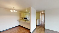 Located at 2301 North Wilbur Road in Spokane Valley, Washington, this single-floor unit offers a practical and well-organized layout designed for comfortable everyday living. The open-concept living and dining area features warm wood-style flooring that transitions seamlessly into the kitchen zone, while plush carpeting defines the living room space. A chandelier adds a welcoming accent above the dining area, and a sliding glass door fills the living room with natural light while providing access to a private balcony with outdoor views.

The kitchen is efficiently designed in a U-shaped configuration, featuring light-toned cabinetry, a double-basin sink, a full suite of white appliances including a refrigerator, electric range, built-in microwave, and dishwasher, as well as a peninsula breakfast bar ideal for casual dining.

The bedrooms are carpeted and well-lit, with one featuring multiple windows that invite natural light and a baseboard heating unit for year-round comfort. The bathrooms include wood-style flooring, a vanity with a countertop sink, and a full tub-shower combination. A dedicated in-unit laundry room accommodates a full-size washer and dryer, adding everyday convenience to this thoughtfully arranged Spokane Valley residence.