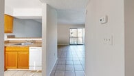 Located at 349 Scottsdale Square in Winter Park, Florida, this one-bedroom, one-bathroom residence offers a practical and well-organized single-floor layout. Light tile flooring runs throughout the main living areas, complementing the neutral wall tones and textured ceilings that give the space a clean, consistent aesthetic.

The open-concept living room is bright and airy, anchored by a sliding glass door that leads to a private balcony, bringing in generous natural light and outdoor views of the surrounding landscape. The kitchen is efficiently laid out with warm honey-toned wood cabinetry, granite-style countertops, white appliances including a refrigerator, range, and dishwasher, and tile flooring that ties seamlessly into the adjoining living area. A pass-through counter connects the kitchen to the living space, enhancing the open feel.

The spacious primary bedroom features tile flooring, a window allowing natural light, and ample wall space. A hallway connects the main living areas to the bedroom and the full bathroom, which includes a tub-shower combination with tiled surround and chrome fixtures. The layout flows logically throughout, making efficient use of the available space. Situated in the desirable Winter Park area, this residence offers comfortable, functional living.