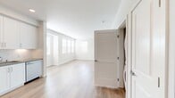 This 680-square-foot, one-bedroom, one-bathroom apartment is located on the second floor at 30950 Hanover Ln, Unit 12-206, in Menifee, CA 92584. The open-concept kitchen and living area is finished with light wood-style flooring throughout and features crisp white cabinetry extending to the ceiling, stainless steel appliances including a French door refrigerator, gas range, built-in microwave, and dishwasher, complemented by a white subway tile backsplash and recessed lighting. The spacious living room is bathed in natural light from multiple windows fitted with blinds, and includes a door leading to a private outdoor balcony area. The 140-square-foot primary bedroom is carpeted and includes a window with outdoor views, providing a quiet retreat. It connects directly to a generously sized walk-in closet outfitted with dual wire shelving systems for ample storage. The full bathroom features light wood-style flooring, a full-size soaking tub with a tiled shower surround, and built-in niche shelving. The unit's neutral color palette, modern finishes, and thoughtful layout create a clean, functional living environment.