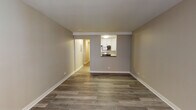 Located at 5101 N Sheridan Rd in Chicago's Edgewater neighborhood, this single-floor unit offers a clean, modern aesthetic throughout. The open living area is anchored by updated luxury vinyl plank flooring in a warm wood tone, neutral gray walls, and crisp white baseboards that lend a fresh, contemporary feel to the space.

The kitchen is accessible via a pass-through window from the living area, offering white shaker-style cabinetry, dark countertops, a classic white subway tile backsplash, and stainless steel appliances including a gas range and over-the-range microwave. A hallway connects the living area to the private bedroom, which features its own window with natural light, a wall-mounted HVAC unit, and baseboard heating.

A generously sized walk-in closet with wire shelving provides ample storage. The bathroom includes a full tub-shower combination lined with white subway tile and chrome fixtures, maintaining the unit's consistent, clean design language. An electrical panel is conveniently located in the hallway. Throughout the unit, consistent flooring and a neutral color palette create a cohesive, move-in-ready environment well-suited for comfortable urban living.
