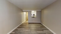 Located at 5101 N Sheridan Rd in Chicago's Edgewater neighborhood, this single-floor unit offers a clean, modern aesthetic throughout. The open living area is anchored by updated luxury vinyl plank flooring in a warm wood tone, neutral gray walls, and crisp white baseboards that lend a fresh, contemporary feel to the space.

The kitchen is accessible via a pass-through window from the living area, offering white shaker-style cabinetry, dark countertops, a classic white subway tile backsplash, and stainless steel appliances including a gas range and over-the-range microwave. A hallway connects the living area to the private bedroom, which features its own window with natural light, a wall-mounted HVAC unit, and baseboard heating.

A generously sized walk-in closet with wire shelving provides ample storage. The bathroom includes a full tub-shower combination lined with white subway tile and chrome fixtures, maintaining the unit's consistent, clean design language. An electrical panel is conveniently located in the hallway. Throughout the unit, consistent flooring and a neutral color palette create a cohesive, move-in-ready environment well-suited for comfortable urban living.