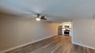 Located at 3333 W Dunlap Ave in Phoenix, Arizona, this single-floor unit offers a clean, modern living environment with consistent finishes throughout. The open-concept living area is spacious and bright, featuring wood-look plank flooring, neutral-toned walls, white baseboards, a textured ceiling, and a ceiling fan with integrated lighting. The space flows naturally into the kitchen, which is well-appointed with white shaker-style cabinetry, subway tile backsplash, dark countertops, and a full suite of stainless steel appliances including a gas range, over-the-range microwave, and refrigerator. Track lighting overhead illuminates the kitchen effectively. The bedrooms are comfortably sized, each featuring the same wood-look flooring, ceiling fans, textured ceilings, and windows fitted with horizontal blinds that allow for natural light. One bedroom includes a door leading to an adjacent closet or storage area. The bathroom is tastefully updated with a floating wood-toned vanity, a white undermount sink, a large mirror, and a tub-shower combo. Wood-look flooring continues into the bathroom, tying the unit together with a cohesive aesthetic throughout.