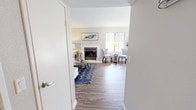 This single-floor residence offers a thoughtfully designed layout that balances comfort and functionality across its key living spaces. The living room serves as the heart of the home, highlighted by a classic white-mantled fireplace, warm hardwood-style flooring, and a large window fitted with vertical blinds that allows natural light to fill the space. Crown molding adds a refined architectural touch to the room's clean, neutral palette.

The kitchen is efficiently arranged with white cabinetry, granite-toned countertops, and a full suite of stainless steel appliances including a range, microwave, and refrigerator. A pass-through window connects the kitchen to an adjacent area, enhancing the open feel. Natural light enters through multiple windows, keeping the space bright and inviting.

Two well-sized bedrooms provide comfortable retreats, each featuring plush carpeting and windows that bring in natural light. The bathroom is neatly appointed with a tub-shower combination, a granite-toned vanity, and ample wall space for storage and décor.

A dedicated in-unit laundry area houses a full-size washer and dryer beneath overhead cabinetry, adding everyday convenience. Throughout the residence, the consistent use of neutral tones, hardwood-style and carpeted flooring, and thoughtful detailing creates a cohesive and welcoming living environment.