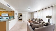 Located at 20202 E Admiral Pl in Catoosa, Oklahoma, this single-story home offers a thoughtfully designed layout with two bedrooms, two bathrooms, and a dedicated living room. The living area is generously proportioned, featuring neutral-toned carpet, bright windows with sheer curtains that invite natural light, and a clean, open feel that connects seamlessly to the rest of the home. A white armoire adds a classic touch to the space. The kitchen is well-equipped with warm wood cabinetry, granite-style countertops, tile flooring, and ample storage — offering both style and practicality. The primary bedroom is a comfortable retreat, complete with plush carpet, a ceiling fan, natural light from a large window with blinds, and a dedicated closet. The second bedroom similarly features a ceiling fan and its own closet, providing functional personal space. Both bathrooms are finished with tile floors, warm wood vanity cabinets, grey countertops, and tub-shower combos. Each bedroom benefits from its own nearby bathroom. The home's neutral color palette and carpet throughout the main living and sleeping areas create a cohesive, comfortable ambiance suited for everyday living.