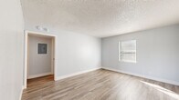 Located at 2280 Mayfair Way in Titusville, Florida, this single-floor home offers a clean, updated interior with a cohesive and functional layout. Light-toned vinyl plank flooring runs throughout the home, complementing the soft gray walls and crisp white baseboards found in every room.

The main living area is open and bright, with natural light filtering through blinds-fitted windows and a textured popcorn ceiling overhead. An electrical panel is conveniently accessible from this space. The kitchen has been thoughtfully updated with white shaker-style cabinetry, light granite-look countertops, and stainless steel appliances including a range and a full-size refrigerator, all set atop matching vinyl plank flooring.

The bedrooms are generously sized, each featuring the same warm flooring and neutral wall tones. Several rooms include ceiling fans and windows that allow natural light to fill the space. At least one bedroom features a double sliding closet with paneled doors, offering ample storage. The bathroom is outfitted with a full tub and shower combination, finished with classic white subway tile surround and chrome fixtures.

The overhead dollhouse view reveals a well-organized, compact floor plan that maximizes usable space throughout. Overall, this home presents a refreshed, move-in-ready interior with a clean, neutral aesthetic.