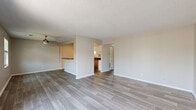 Located at 1715 Theatre Dr in Evansville, Indiana, this single-floor, 2-bedroom, 2-bathroom home offers a thoughtfully designed layout with consistent, contemporary finishes throughout. Wood-look luxury flooring flows seamlessly from room to room, complemented by neutral-toned walls and white trim that create a clean, cohesive aesthetic.

The open-concept kitchen and living area serves as the heart of the home. The kitchen is equipped with stainless steel appliances, including an electric range and refrigerator, white shaker-style cabinetry, a tile backsplash, dark countertops, and a peninsula with bar seating — ideal for casual dining. The adjacent living room is bright and open, featuring a large sliding glass door that invites natural light and provides outdoor access.

Both bedrooms feature ceiling fans with light fixtures, windows with blinds for natural light and privacy, and textured ceilings. The spacious primary bedroom offers a comfortable and private retreat, while the second bedroom includes a built-in closet with sliding doors. A connecting hallway ties the layout together efficiently.

The two bathrooms are finished with dark countertop vanities, wood-look flooring, and brushed nickel hardware. Each includes a full tub and shower combination. The overall ambiance is clean, modern, and move-in ready.