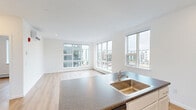 Located at 339 Garden Street in South Burlington, Vermont, this well-designed 2-bedroom, 2-bathroom residence offers a bright, contemporary living experience across a single floor. Light hardwood flooring flows throughout the space, lending warmth and continuity to every room.

The open-concept living, dining, and kitchen area serves as the heart of the home. Large multi-pane windows flood the space with natural light and offer views of the surrounding neighborhood. The kitchen features a central island with a dark granite-style countertop and undermount sink, white shaker-style cabinetry, and stainless steel appliances including a refrigerator, range, microwave, and dishwasher.

The primary bedroom is generously proportioned, featuring a large picture window with neighborhood views and a double-door closet. The second bedroom is a comfortable, well-lit room with its own window. Five closets throughout the unit provide ample storage. A dedicated laundry area houses a stacked washer and dryer unit for added convenience.

Both bathrooms are finished with white vanities, large mirrors, and hardwood-style flooring. One bathroom includes a tub/shower combination. A ductless mini-split system provides efficient climate control, complemented by baseboard heating throughout.