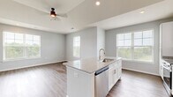 Located on Founder's Lane in Lebanon, Ohio, this single-floor, 2-bedroom, 2-bathroom home offers a thoughtfully designed layout with modern finishes throughout. The open-concept kitchen and living area serves as the heart of the home, featuring warm wood-look flooring, vaulted ceilings, and abundant natural light from large windows with views of surrounding greenery. The kitchen is well-equipped with white shaker cabinetry, granite countertops, stainless steel appliances, and a central island with a sink — ideal for both cooking and casual dining.

The primary bedroom is a comfortable retreat, complete with soft carpeting, generous wall space, and direct access to an en-suite bathroom. The en-suite features white cabinetry, a granite-topped vanity with an undermount sink, and wood-look flooring. The second bedroom also offers plush carpet and a sliding-door closet, providing practical storage. A dedicated walk-in closet with wire shelving adds further organizational convenience.

The second bathroom mirrors the refined finishes seen throughout the home. A dedicated laundry room houses a full-size washer and dryer with overhead wire shelving. Neutral gray walls and consistent flooring tie the entire space together, creating a clean, cohesive, and move-in-ready atmosphere.