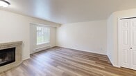 Located at 8615 83rd Street Ct SW in Lakewood, Washington, this 2-bedroom, 3-bathroom single-floor home offers a well-organized layout with a welcoming entrance and consistent wood-style flooring throughout. The open living and dining area serves as the heart of the home, highlighted by a tile-surround fireplace, a ceiling fan, and sliding glass doors dressed with vertical blinds that invite natural light. Adjacent to the living area, the kitchen is thoughtfully appointed with grey shaker-style cabinetry, marble-look countertops, stainless steel appliances including a refrigerator, range, and microwave, and a peninsula with a double-basin sink — ideal for both cooking and casual dining. A pantry provides additional storage. The primary bedroom offers a comfortable, sunlit retreat with a window and dedicated closet, while the second bedroom is equally bright and versatile. Three full bathrooms, each featuring a tub/shower combination with curved curtain rods and clean white finishes, ensure ample convenience. Additional highlights include a dedicated laundry area, three closets for generous storage, and baseboard heating throughout. The neutral color palette and clean finishes create a bright, move-in-ready atmosphere.