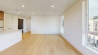Located at 707 S Berendo St in Los Angeles, this modern 2-bedroom, 1-bathroom residence offers a thoughtfully designed open-concept layout with contemporary finishes throughout. Light wood-tone flooring flows seamlessly across the entire space, complementing the clean white walls and recessed lighting that lend a bright, airy atmosphere.

The combined kitchen and living area serves as the heart of the home. The kitchen is outfitted with stainless steel appliances including a gas range, microwave, and refrigerator, paired with rich wood cabinetry and a striking quartz-topped island featuring an undermount sink — ideal for both cooking and casual dining. A large window above the countertop frames views of the surrounding cityscape, flooding the space with natural light. The living area opens directly onto a private balcony through sliding glass doors, extending the living space outdoors with city views.

Both bedrooms are well-proportioned and serene, featuring recessed lighting, generous closet storage with sleek floor-to-ceiling wood-paneled doors, and ample natural light. The bathroom is elegantly finished with large-format marble-style tile on both the floors and walls, a soaking tub with glass enclosure, matte black fixtures, and a wood-accented vanity, creating a spa-like retreat.