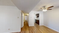 Located at 10330 Gateway Blvd N in El Paso, TX, this single-story, 3-bedroom, 2-bathroom home offers a practical and well-organized layout. The living room features wood-look flooring and a ceiling fan with lighting, creating a comfortable main gathering space. An open pass-through connects the living area to the kitchen, which is equipped with dark wood cabinetry, granite-style countertops, a dishwasher, and a full-size refrigerator. A hallway extends from the living area, leading to all three bedrooms and both bathrooms. The bedrooms are carpeted and receive natural light through window treatments; each includes a closet for storage. The primary bedroom offers a generous footprint with ample wall space. Both bathrooms feature wood-toned vanities with granite-style countertops and tub/shower combinations — one with a tiled surround and one with a shower-curtain setup. White cabinetry above the vanity provides additional storage. Throughout the home, textured ceilings and clean white walls create a bright, neutral backdrop. The consistent use of wood-look flooring in the main living spaces and carpet in the bedrooms offers a clear functional distinction between areas, making this a well-suited home for everyday living.