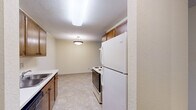 This two-bedroom, one-bathroom residence in Roseville, Minnesota, offers a well-organized single-floor layout designed for comfortable everyday living. The spacious living room features plush carpeting, a baseboard heating system, and a sliding glass door that opens onto a private balcony with outdoor views — bringing in natural light and a connection to the surrounding greenery. The combined kitchen and dining area is outfitted with warm wood-tone cabinetry, a full-size refrigerator, a range, and a sink, all set on easy-care tile flooring beneath ceiling-mounted lighting. Both bedrooms are carpeted and feature ceiling fans with light fixtures and windows that frame wooded views. The primary bedroom is notably spacious, offering two closets for ample storage. The second bedroom also includes a ceiling fan and a sizable closet. Throughout the unit, an impressive total of seven closets ensures exceptional storage capacity. The full bathroom is clean and functional, featuring a tub-shower combination with a curtain rod. A connecting hallway ties the layout together efficiently. With neutral wall tones and consistent finishes throughout, this residence provides a calm, move-in-ready environment in a convenient Roseville location.