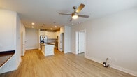 Located in Destin, Florida, this well-appointed 2-bedroom, 2-bathroom residence offers a thoughtfully designed single-floor layout combining modern style with everyday functionality. Light-toned luxury vinyl plank flooring flows seamlessly throughout the entire space, creating a cohesive and clean aesthetic.

The open-concept kitchen and living area serves as the heart of the home. The kitchen is outfitted with white shaker cabinetry, subway tile backsplash, dark quartz countertops, and a full suite of stainless steel appliances including a refrigerator, range, and built-in microwave. A central island with a undermount sink and pendant lighting in brushed gold provides additional workspace and casual seating. Recessed lighting and a ceiling fan complete the living area, which receives ample natural light through multiple windows and a glass door.

Both bedrooms are comfortably sized, each featuring a ceiling fan and a window with blinds that allow for natural light and privacy. The primary bathroom includes a single-sink vanity with dark countertops, white cabinetry, a framed mirror, and access to a walk-in closet with built-in wire shelving. The second bathroom offers a tiled shower and matching clean finishes. An additional walk-in closet with wire shelving provides generous storage throughout the home.