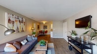 Located at 7027 W Friendly Ave in Greensboro, NC, this single-floor residence offers a thoughtfully designed layout that balances comfort and functionality. The open-concept living area features warm hardwood-style flooring, neutral walls, and large windows that invite natural light, creating an inviting and airy atmosphere. The living room provides ample space for relaxing, flowing seamlessly into a dedicated dining area framed by bold decorative wall art.

The kitchen is outfitted with crisp white cabinetry, granite-style countertops, a built-in sink, and black appliances, offering a clean and efficient workspace. Hardwood-style flooring continues through the kitchen, maintaining a cohesive aesthetic throughout the main living spaces.

The bedroom is generously proportioned, featuring plush carpeting, a ceiling fan with light fixture, and a window that provides natural light and ventilation. The full bathroom includes a wide vanity with ample counter space, wood-style flooring, and a shower-tub combination.

A dedicated in-unit laundry room houses a full-size washer and dryer with overhead shelving for added storage convenience. The entry area is open and welcoming, with multiple interior doors providing easy access to the various rooms. Overall, this residence offers a well-balanced, move-in-ready living experience in a convenient Greensboro location.