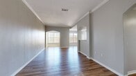 This 1,150 sq ft apartment at Ridge at Blue Hills offers 3 bedrooms, 3 bathrooms, and a well-designed single-floor layout in Braintree, MA. The spacious living room features warm hardwood-style flooring, crown molding, elegant arched doorways, and neutral gray walls that create an open, inviting atmosphere. The galley-style kitchen is outfitted with dark espresso cabinetry, white quartz countertops, a tile backsplash, and stainless steel appliances, including a refrigerator, dishwasher, and range. A dedicated in-unit laundry room houses a full-size washer and dryer with additional wire shelving for storage. The primary bedroom spans 140 sq ft and includes plush carpeting, a ceiling fan, a walk-in closet, and a private en-suite bathroom. Additional bedrooms also feature carpet flooring, ceiling fans, and natural light from vertical-blind windows. The three bathrooms are finished with slate tile flooring, dark vanities, and tiled surrounds. Two hallways and two closets provide ample storage throughout. The unit combines functional design with modern finishes, making it a comfortable and practical home.