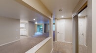 This single-floor residence offers a functional and well-organized layout designed for comfortable everyday living. The open-concept living area is generously proportioned, featuring neutral-toned carpet, a textured ceiling, and recessed lighting that creates a warm, inviting atmosphere. Large windows fitted with blinds allow natural light to filter through while offering views of the surrounding greenery. A sliding glass door leads directly to an outdoor balcony, further connecting the interior to the natural environment outside.

The kitchen is efficiently arranged in a U-shaped configuration, outfitted with white cabinetry, light countertops, a stainless steel sink, and appliances including a range and refrigerator. It is separated from the living space by a half-wall pass-through, maintaining a sense of openness throughout.

A carpeted hallway connects the private areas of the residence, leading to multiple well-sized bedrooms. Each bedroom features neutral carpet flooring, baseboard heating, and windows that frame outdoor tree views. The bathroom includes a wide vanity countertop, a framed mirror with overhead lighting, and built-in cabinetry for ample storage. Throughout the residence, a consistent neutral color palette and clean white trim contribute to a cohesive and move-in-ready aesthetic.