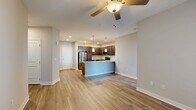 Located at 5220 Center St in Williamsburg, Virginia, this well-appointed 2-bedroom, 2-bathroom residence offers a thoughtfully designed single-floor layout. The open-concept living and kitchen area serves as the heart of the home, featuring warm wood-look flooring, neutral tones, and a ceiling fan that enhances the bright, airy atmosphere. Large windows allow ample natural light to fill the living space, which also includes access to an outdoor balcony.

The kitchen is a standout feature, showcasing rich dark-stained cabinetry, granite countertops, a subway tile backsplash, and a full suite of stainless steel appliances including a refrigerator, range, and microwave. Elegant pendant lighting above the kitchen island adds a refined touch, while the open layout keeps the space connected to the living area.

Both bedrooms are carpeted for comfort and include ceiling fans. The generously sized primary bedroom offers dedicated closet space and an adjoining bathroom. The bathrooms are finished with granite vanity tops, dark cabinetry, and wood-look flooring, with one bathroom featuring a glass-enclosed walk-in shower with tile surround. Additional conveniences include a dedicated laundry area, hallway, and two closets throughout the residence.