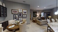 Located in Houston's desirable River Oaks area, this thoughtfully designed single-floor residence at 1916 W Gray Street offers a seamless blend of contemporary style and functional living. The open-concept layout connects the living, dining, and kitchen areas, all finished with gleaming large-format tile flooring throughout. The kitchen is appointed with dark espresso cabinetry, granite countertops, stainless steel appliances, and under-cabinet lighting, creating a polished, chef-ready environment. The dining area features a curated gallery wall of framed artwork alongside dark wood display cabinets, adding an artistic sophistication to mealtimes. The living room is anchored by neutral-toned furnishings and flows naturally toward the private balcony, which is a standout feature complete with a built-in fireplace, wall-mounted television, and outdoor seating — an ideal setting for relaxing with courtyard views. The primary bedroom offers plush carpeting, decorative mirrored wall panels, and direct balcony access through sleek black-framed glass sliding doors. The en-suite bathroom includes a soaking tub, glass-enclosed walk-in shower, dark granite vanity, and tile flooring. A dedicated in-unit laundry area with overhead cabinetry adds everyday convenience to this well-appointed Houston residence.