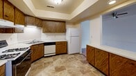 Located at 2122 E Bristol St in Elkhart, Indiana, this single-floor, 2-bedroom, 1-bathroom home offers a practical and comfortable layout across a generously sized floor plan. The kitchen is a functional centerpiece, featuring warm wood cabinetry, a gas range, dishwasher, refrigerator, and tile flooring beneath a tray ceiling with flush-mount lighting. A convenient pass-through counter connects the kitchen to adjacent living areas. The dining room flows naturally from the kitchen and includes durable hardwood-style flooring and a ceiling fan, creating a bright, airy feel. The spacious living room is finished with plush carpet and benefits from a sliding glass door that invites natural light. Both bedrooms are carpeted and well-sized, with the primary bedroom offering generous dimensions and access to a large walk-in closet with dual hanging rods. Additional closets throughout the home provide exceptional storage capacity. The full bathroom is neatly appointed with tile flooring, a tub/shower combination, a white vanity with marble-style countertop, and a wall mirror. A dedicated utility room houses the HVAC system and electrical panel, and includes built-in shelving for added storage. The home's layout is straightforward and efficient, making it an informative and accessible space.