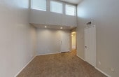 Located at 7415 Tallow Wind Trl in Fort Worth, TX, this single-floor residence offers a thoughtfully designed layout with a variety of notable architectural features. The living area immediately impresses with dramatically soaring ceilings and a bank of high clerestory windows that flood the space with natural light. Recessed lighting complements the abundant daylight, while neutral-toned carpet and smooth walls provide a clean, move-in-ready aesthetic throughout.

The kitchen is equipped with dark espresso-toned cabinetry, a peninsula breakfast bar with a light countertop surface, and a range with overhead ventilation hood. Hardwood-style flooring anchors the kitchen, which opens toward the carpeted living and dining areas via mirrored sliding doors, enhancing the sense of openness.

The bedrooms offer comfortable proportions, each with plush carpeting, closet access, and vaulted or angled ceilings that add visual interest. One bedroom features a sliding door opening to the exterior. The bathroom includes a full soaking tub and shower combination, surrounded by neutral ceramic tile that extends from floor to ceiling, providing a clean and functional finish.

Overall, this home presents a practical and inviting interior, combining open-concept living spaces with well-defined private areas in a quiet Fort Worth neighborhood.