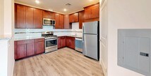 This single-floor unit offers a thoughtfully designed layout with a clean, contemporary aesthetic throughout. The kitchen is a standout feature, showcasing rich cherry wood cabinetry, granite countertops, a light subway tile backsplash, and a full suite of stainless steel appliances including a gas range, microwave, dishwasher, and refrigerator. Light hardwood-style luxury vinyl plank flooring flows seamlessly throughout the entire unit, lending warmth and continuity to every room.

The open living and dining areas are bright and airy, benefiting from large windows that invite natural light and offer views of surrounding greenery. The neutral, warm beige walls provide a versatile backdrop throughout the space, complementing the light flooring and white trim.

The bedrooms are generously proportioned, each featuring large windows that maximize natural light and provide pleasant outdoor views, along with ample space for furnishings.

The bathroom is finished with refined marble-patterned wall tiles that extend to mid-height, paired with large-format gray wood-look floor tiles. A soaking tub, toilet, and vanity with granite countertop and rich wood cabinetry complete the bathroom's polished look. The overall ambiance of the unit is fresh, modern, and move-in ready.