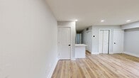 This thoughtfully updated 2-bedroom, 1-bathroom single-floor home in Glen Burnie, MD offers a clean, modern aesthetic throughout. Light wood laminate flooring flows consistently across all rooms, complemented by crisp white walls and trim that create a bright, cohesive feel. The open-concept kitchen is a standout feature, showcasing white shaker cabinets with matte black hardware, white countertops, stainless steel appliances including a gas range, built-in microwave, and dishwasher, and an eye-catching teal herringbone tile backsplash. A peninsula counter connects the kitchen to the main living area. The living room is open and well-lit, with recessed lighting adding to the airy atmosphere. Both bedrooms offer natural light through windows with blinds, and the primary bedroom includes a closet with double doors. The home is exceptionally well-equipped with five closets total, providing abundant storage throughout. The full bathroom features bold teal subway tile lining the tub surround from floor to ceiling, paired with a white vanity and matte black fixtures for a striking contrast. A dedicated laundry area and hallway round out the efficient, functional layout of this well-appointed home.