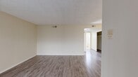 Located at 847 Irolo St in the heart of Los Angeles, this 2-bedroom, 1-bathroom unit offers a practical and well-organized single-floor layout. Throughout the living areas and bedrooms, wood-look laminate flooring in a neutral gray-brown tone provides a clean, cohesive aesthetic, complemented by cream-colored walls and textured ceilings.

The living room serves as the main gathering space, featuring a large sliding window with vertical blinds that allows natural light to fill the room. A front entry door opens directly into this area, creating a welcoming flow into the unit. Two hallways connect the living area to the rest of the unit, ensuring efficient circulation.

The primary bedroom is a well-proportioned room with a window that brings in additional natural light, while the second bedroom offers similar wood-look flooring and neutral walls. Both rooms feature open closet space visible from the hallway.

The kitchen is equipped with wood-trimmed cabinetry, a double stainless steel sink beneath a window with vertical blinds, light-speckled countertops, and white lower cabinet doors, offering ample storage and workspace.

The bathroom includes a combined tub and shower enclosed by sliding glass doors, a vanity with mirror, a window for ventilation, and tile flooring, rounding out the functional amenities of this centrally located Los Angeles unit.