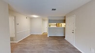 Located at 1500 Willow Trail Drive in Norcross, GA, this single-floor, 2-bedroom, 2-bathroom home offers a well-organized layout designed for comfortable everyday living. The open-concept living and kitchen area serves as the heart of the home, featuring warm wood-style luxury vinyl plank flooring, neutral walls, and a textured ceiling. The kitchen is equipped with gray cabinetry, a stainless steel refrigerator, an electric range, subway tile backsplash, and a marble-style countertop that extends to a pass-through breakfast bar, seamlessly connecting to the living area. A central hallway leads to both bedrooms, each carpeted for comfort. The primary bedroom includes a ceiling fan with light fixture, a window for natural light and outdoor views, and access to a walk-in closet outfitted with wire shelving along multiple walls. The second bedroom is also carpeted and features its own window. Both bathrooms include a tub-shower combination with tiled surrounds and wood-style flooring. The home also features two closets for additional storage. The overall aesthetic is clean and modern with a neutral, light-toned palette throughout.