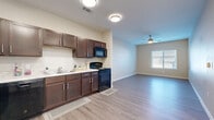 Located at 4011 S Belt Line Rd in Balch Springs, TX, this single-story, 2-bedroom, 1-bathroom unit offers a well-designed layout that maximizes its comfortable footprint. Light wood-look flooring flows consistently throughout the main living areas and bedrooms, creating a cohesive and clean aesthetic.

The kitchen is a functional centerpiece, featuring rich dark espresso cabinetry with brushed nickel hardware, light countertops, and a full suite of black appliances including a refrigerator, range, microwave, and dishwasher. The kitchen opens naturally into the living area, which is brightened by a window with blinds and topped with a ceiling fan for added comfort.

Both bedrooms are well-proportioned, with the spacious primary bedroom offering ample room for furnishings, a ceiling fan, and natural light from a window. The second bedroom is similarly appointed with neutral-toned walls and a window. A closet provides dedicated storage within the unit.

The bathroom is finished with light tile flooring, a dark vanity with a white countertop sink, a large mirror, and a clean, minimalist design. A hallway connects the rooms efficiently, contributing to the unit's practical and organized floor plan. The overall ambiance is modern, neutral, and move-in ready.