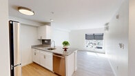 This well-designed one-bedroom, one-bathroom unit at 898 Farmington Ave in West Hartford, CT offers a clean, modern aesthetic throughout its efficiently organized floor plan. Light hardwood flooring flows seamlessly from the entrance through the open-concept kitchen and living area, creating a bright and cohesive atmosphere.

The kitchen is a standout feature, equipped with white shaker cabinets, granite countertops, a subway tile backsplash, stainless steel appliances—including a refrigerator, range, microwave, and dishwasher—and a peninsula with a built-in sink that doubles as a breakfast bar. The adjacent living area benefits from a large window that allows generous natural light and provides open views of the surrounding area.

The bedroom is a comfortable, well-proportioned space with large windows that flood the room with sunlight and offer outdoor views. A wall-mounted mini-split HVAC unit ensures year-round climate control, and a bi-fold closet provides practical built-in storage.

The bathroom is clean and contemporary, featuring a white double-sink vanity with a wide mirror, tile flooring, and a full tub-shower combo with white tile surround. The entrance provides a welcoming transition into the unit, completing this thoughtfully laid-out and move-in-ready home.
