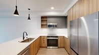 This contemporary 1-bedroom apartment in Redmond, WA offers 690 square feet of thoughtfully designed living space. The open-concept floor plan seamlessly integrates the living room and kitchen, creating a spacious feel. Large windows flood the rooms with natural light and provide scenic city views.

The sleek kitchen boasts modern wood cabinetry, stainless steel appliances, and a convenient island with pendant lighting. The bathroom features clean lines with white tiles and a modern vanity. The bedroom, measuring 160 square feet, offers ample space and includes a ceiling fan for comfort.

Throughout the apartment, light-toned wood flooring adds warmth and continuity. The unit includes in-unit laundry with stacked washer and dryer for convenience. Two hallways and two closets provide additional storage options.

The apartment's design emphasizes a minimalist aesthetic with crisp white walls and simple, functional fixtures. Its layout maximizes the use of space, making it an ideal choice for urban professionals or small families seeking a contemporary living environment in the heart of Redmond.