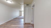 Located at 1420 W Glen Ave in Peoria, Illinois, this single-floor unit offers a practical and well-organized layout across its living spaces. The entry area features wood-look vinyl flooring and a louvered bi-fold closet door, providing convenient storage right at the entrance. This flooring extends through the hallway and into the kitchen and dining areas, creating a cohesive feel throughout the common spaces.

The galley-style kitchen is efficiently designed with white cabinetry, gray laminate countertops, a stainless steel sink, a dishwasher, and a coil-top electric range. Upper and lower cabinets line both sides of the kitchen, maximizing storage and counter space. Adjacent to the kitchen is an open dining area that benefits from natural light and a clean, neutral palette.

The living room is carpeted and notably bright, featuring a sliding glass door that opens to a private balcony overlooking an outdoor area — an excellent source of natural light and ventilation. The textured ceiling adds a classic touch to the space.

Both bedrooms are carpeted and include sliding panel closets with built-in shelving and hanging rods. One bedroom features a window with a view of the surrounding greenery. The full bathroom is equipped with a wood-framed vanity mirror, a single-sink vanity with under-cabinet storage, and a tub-shower combination.
