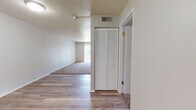 Located at 1420 W Glen Ave in Peoria, Illinois, this single-floor unit offers a practical and well-organized layout across its living spaces. The entry area features wood-look vinyl flooring and a louvered bi-fold closet door, providing convenient storage right at the entrance. This flooring extends through the hallway and into the kitchen and dining areas, creating a cohesive feel throughout the common spaces.

The galley-style kitchen is efficiently designed with white cabinetry, gray laminate countertops, a stainless steel sink, a dishwasher, and a coil-top electric range. Upper and lower cabinets line both sides of the kitchen, maximizing storage and counter space. Adjacent to the kitchen is an open dining area that benefits from natural light and a clean, neutral palette.

The living room is carpeted and notably bright, featuring a sliding glass door that opens to a private balcony overlooking an outdoor area — an excellent source of natural light and ventilation. The textured ceiling adds a classic touch to the space.

Both bedrooms are carpeted and include sliding panel closets with built-in shelving and hanging rods. One bedroom features a window with a view of the surrounding greenery. The full bathroom is equipped with a wood-framed vanity mirror, a single-sink vanity with under-cabinet storage, and a tub-shower combination.