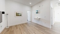 Located at 418 N Norton Ave in the heart of Los Angeles, this 4-bedroom, 2-bathroom home offers a thoughtfully designed single-floor layout with modern finishes throughout. Light wood-tone flooring flows seamlessly across all living areas, creating a cohesive and airy aesthetic complemented by crisp white walls and recessed lighting.

The contemporary kitchen is a standout feature, showcasing rich dark wood cabinetry that extends to the ceiling, white quartz countertops, a decorative arabesque tile backsplash, and a full suite of stainless steel appliances including a gas range, built-in microwave, dishwasher, and refrigerator.

The home includes two living areas, offering flexible space for entertaining or relaxing. The bedrooms are bright and well-proportioned, with large windows that fill the rooms with natural light and provide open views of the surrounding Los Angeles neighborhood. The spacious primary bedroom includes access to a dedicated closet with built-in shelving, drawers, and hanging rods.

The two bathrooms each carry a distinct character: one features large-format neutral tile with a glass-enclosed shower-tub combo and modern wood vanity, while the second is finished with decorative patterned floor tiles. A central hallway connects the layout efficiently, rounding out this clean, modern Los Angeles home.