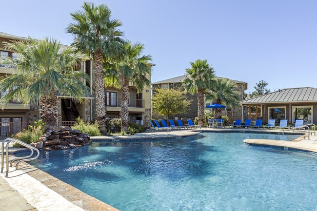 Piscina inspirada en un resort con exuberantes palmeras y áreas de descanso. - Azul