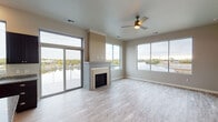 This contemporary single-floor residence is thoughtfully designed with an emphasis on natural light and scenic waterfront views. The open living area serves as the centerpiece of the home, featuring light wood-style flooring, a sleek fireplace framed by a neutral surround, and a ceiling fan overhead. Floor-to-ceiling sliding glass doors lead to a private balcony with cable railings, seamlessly blending indoor and outdoor living while framing stunning views of the water and surrounding landscape.

The kitchen is well-appointed with rich dark cabinetry, granite countertops, stainless steel appliances including a range, microwave, refrigerator, and dishwasher, complemented by a large window that continues the waterfront theme.

The bedrooms are generously sized, each equipped with ceiling fans and large windows offering sweeping outdoor views — one bedroom in particular features a wide, panoramic window showcasing the waterfront scenery. The primary bathroom includes a dual-sink vanity with granite countertops, dark cabinetry, and a walk-in shower. A secondary bathroom mirrors the same refined finishes.

Additional conveniences include an in-unit laundry room with a full-size washer and dryer, wire shelving for storage, and light wood-style flooring carried throughout the entire residence, creating a cohesive and modern aesthetic.